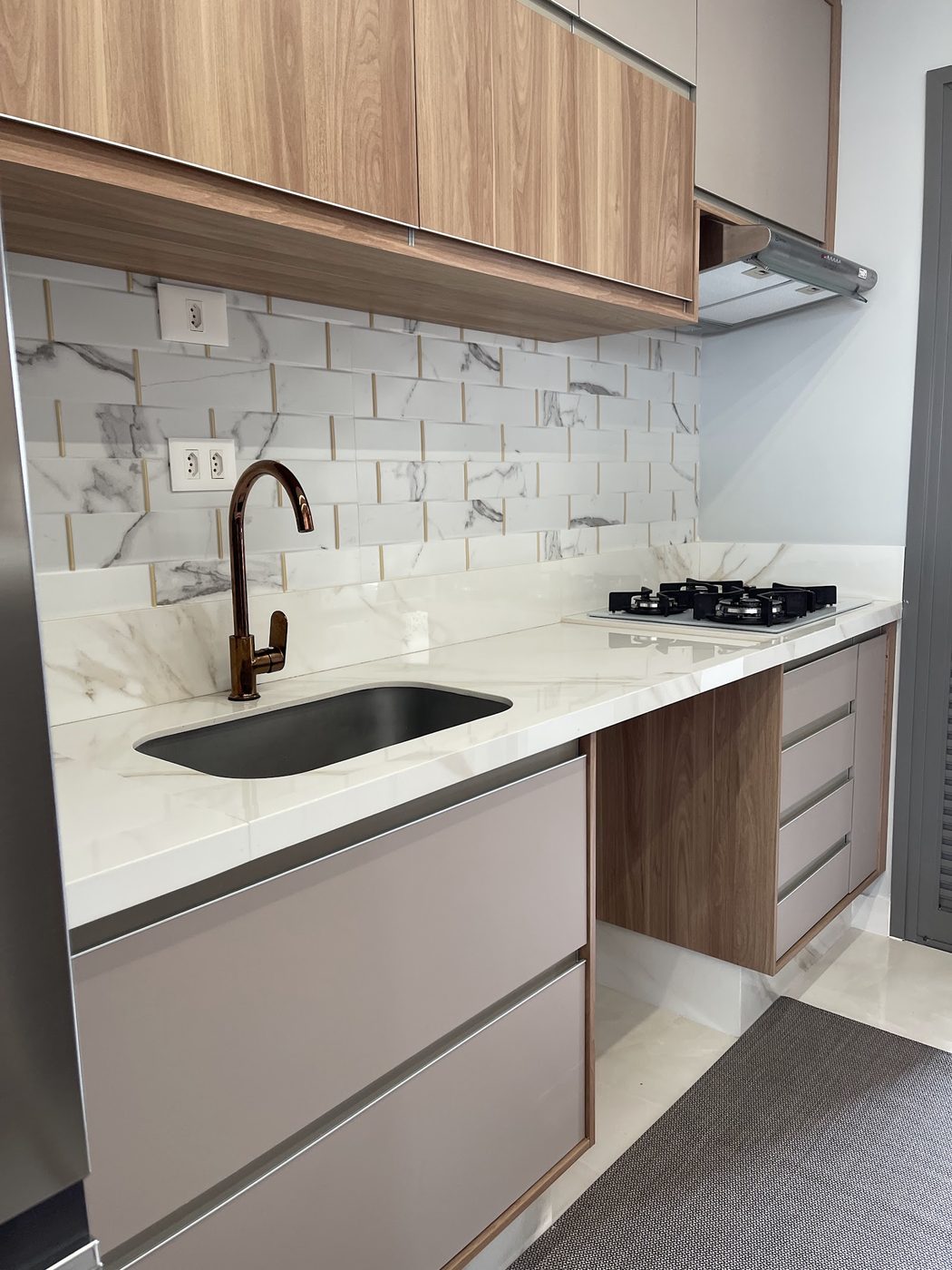 Foto original de bancada clara com cuba embutida e recorte de cooktop no acervo da Pedras Vitória